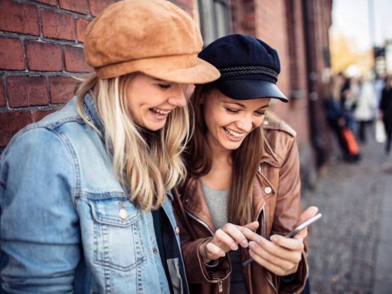 Friends using smartphones to crack the detective case during the City Detective city game of Qugato